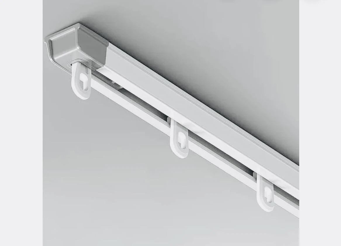 A ceiling-mounted curtain channel with its gliders.